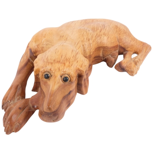 182 - A carved softwood study of a recumbent hound, L52cm