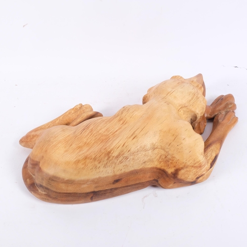 182 - A carved softwood study of a recumbent hound, L52cm