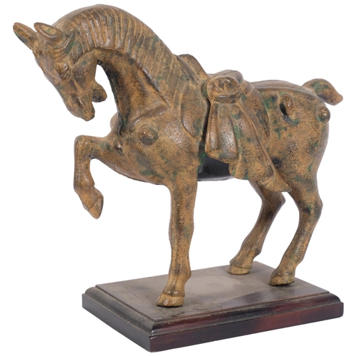 1019 - A patinated metal Tang style horse on stand, H24cm