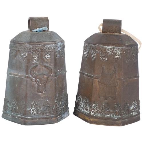 1042 - A pair of hexagonal embossed bronze cowbells, with cow's head and building decoration, and wooden cl... 