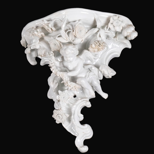 928 - A German porcelain wall bracket, with applied flowers and cherub (some petals chipped), H21cm