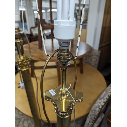 2575 - Two similar brass Corinthian column standard lamps. Tallest height to bayonet 142cm.