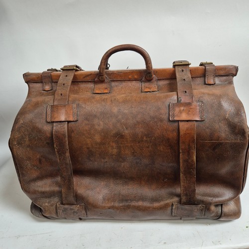 92 - A large Antique leather Gladstone travel bag, with hinged folding sides and leather straps, by John ... 