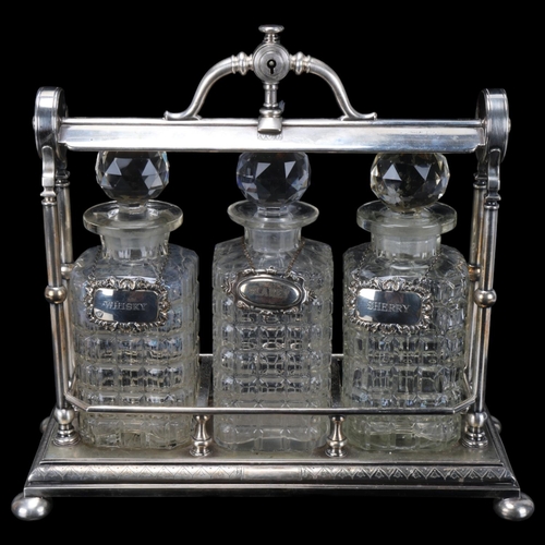 238 - A Victorian electroplate 3-bottle tantalus, containing 3 moulded glass decanters, with silver wine l... 