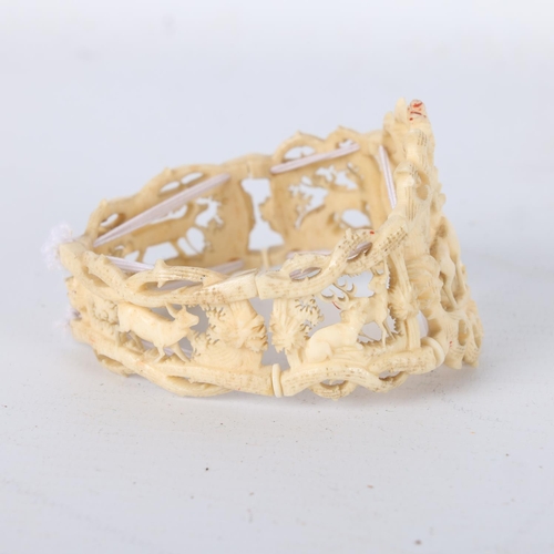 259 - A 19th century carved and pierced bone bracelet, depicting stags in woodland, central panel height 4... 