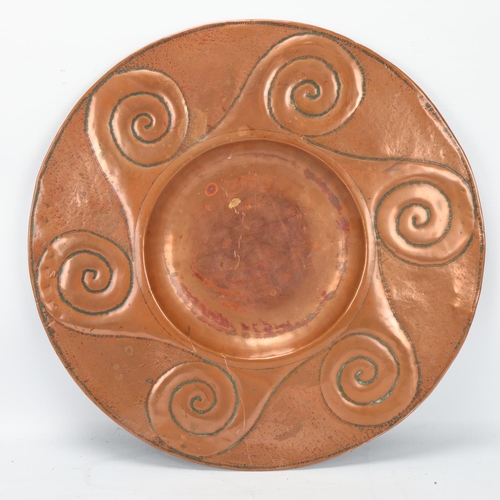 56 - An Arts and Craft embossed copper tray on stylised brass stand, no maker's marks, diameter 42cm