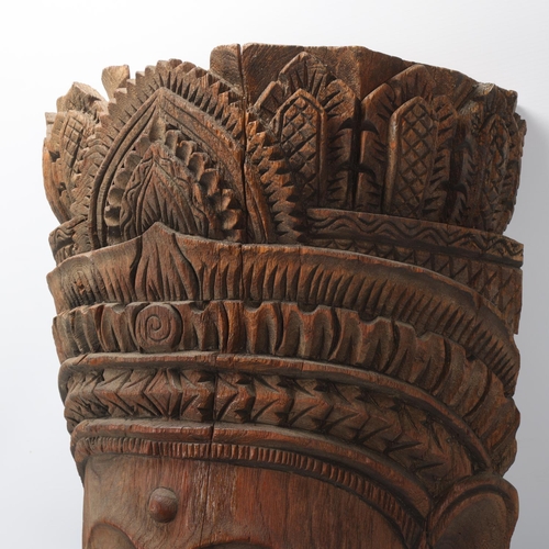 93 - A large Burmese relief carved wood mask wall carving, height 67cm