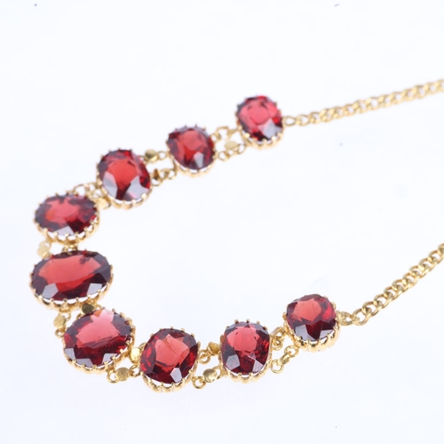 1161 - An Edwardian graduated garnet line bracelet, claw set with oval mixed-cut garnets, on curb link chai... 