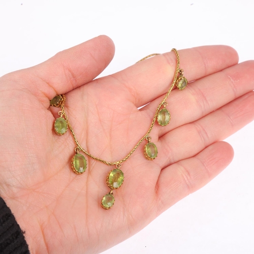 1166 - An Edwardian peridot fringe necklace, circa 1910, claw set with oval mixed-cut peridot drops, on unm... 