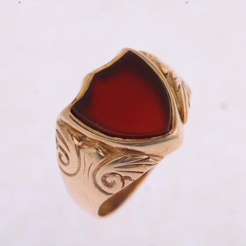 1177 - An early 20th century 9ct rose gold carnelian shield seal signet ring, Birmingham 1914, foliate engr... 