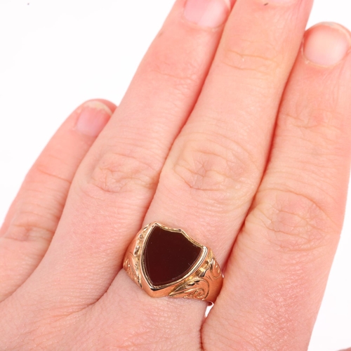 1177 - An early 20th century 9ct rose gold carnelian shield seal signet ring, Birmingham 1914, foliate engr... 