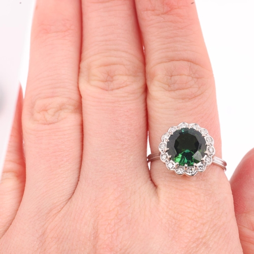 1180 - An 18ct white gold green tourmaline and diamond flowerhead cluster ring, centrally claw set with 3ct... 