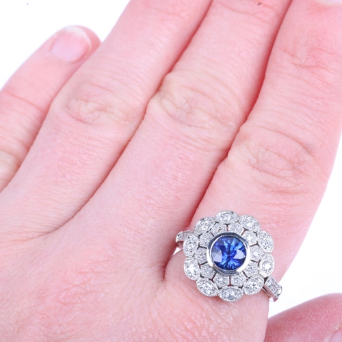 1228 - A platinum sapphire and diamond flowerhead cluster ring, maker JC, set with 1ct round-cut sapphire s... 