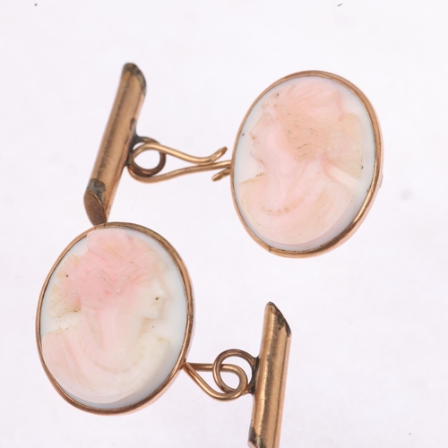 1293 - A pair of early 20th century pink coral cameo cufflinks, relief carved depicting female profiles, ap... 