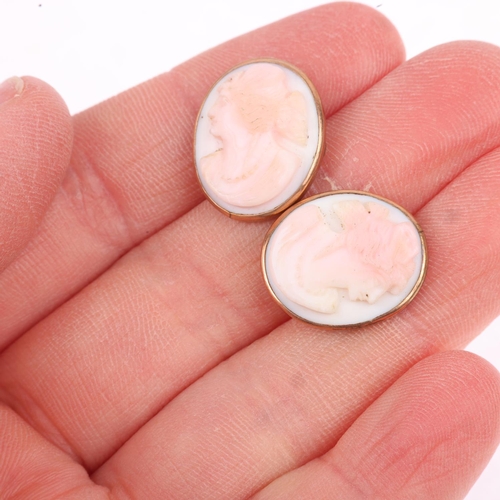 1293 - A pair of early 20th century pink coral cameo cufflinks, relief carved depicting female profiles, ap... 