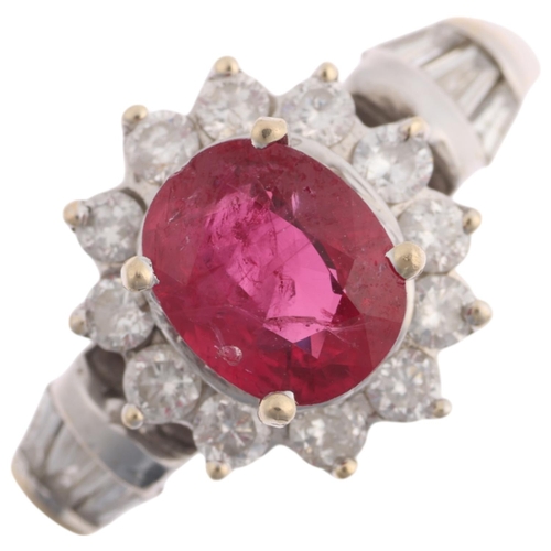 1350 - An 18ct white gold ruby and diamond flowerhead cluster ring, claw set with 1.1ct oval mixed-cut ruby... 