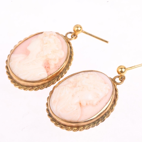 1355 - A pair of 9ct gold pink coral cameo earrings, relief carved depicting female profiles, with stud fit... 