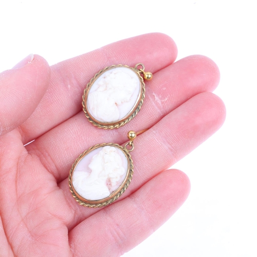 1355 - A pair of 9ct gold pink coral cameo earrings, relief carved depicting female profiles, with stud fit... 