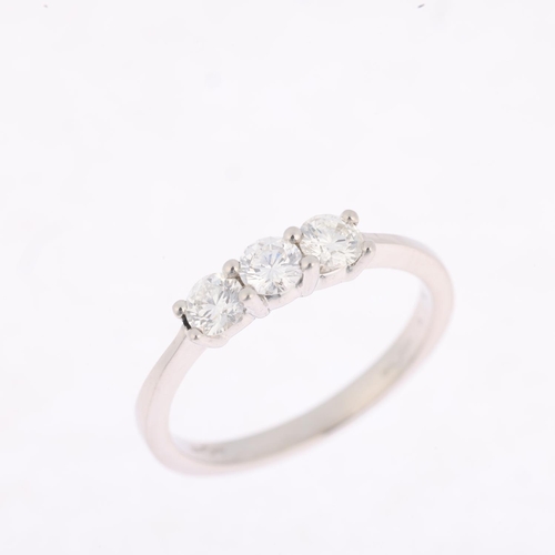 1402 - A platinum three stone diamond ring, claw set with modern round brilliant-cut diamonds, total diamon... 