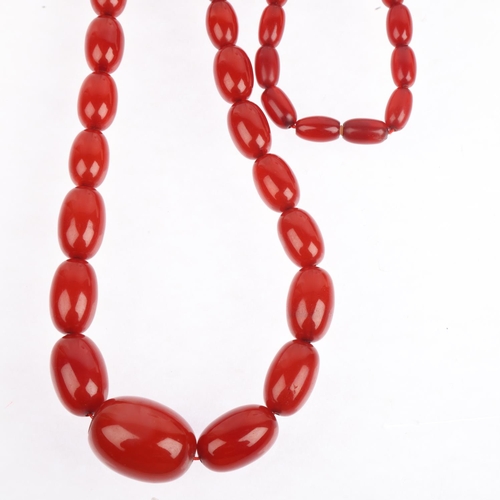 1526 - A long single-strand graduated cherry amber bead necklace, beads measure: 28.3-12.9mm, 46cm, 69.9g