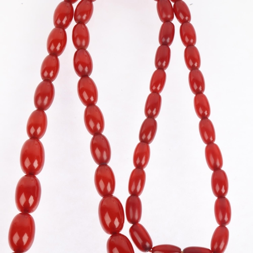 1526 - A long single-strand graduated cherry amber bead necklace, beads measure: 28.3-12.9mm, 46cm, 69.9g