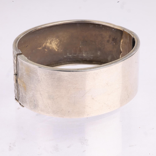 1577 - A Victorian sterling silver hinged bangle, engraved floral decoration, band width 24.5mm, internal c... 