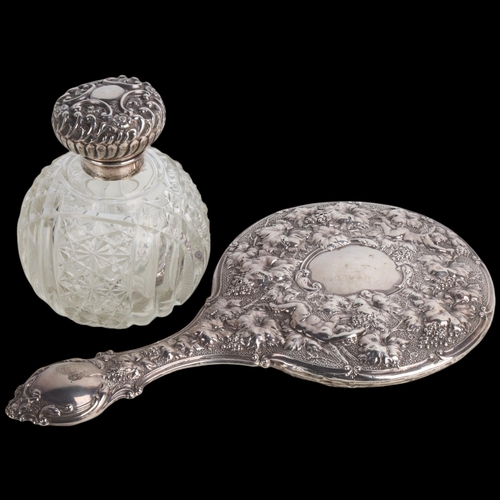 1936 - An Edwardian silver dressing table hand mirror, Birmingham 1903, and a silver-mounted glass scent bo... 