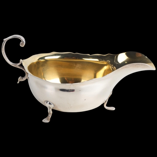 1952 - An Edwardian silver sauce boat, Wilson & Gill, London 1903, C-shaped handle with gilt interior, 15cm... 