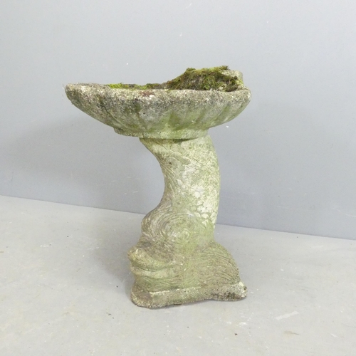 2621 - A two-section weathered concrete bird bath with shell design on oriental fish base. Height 50cm.