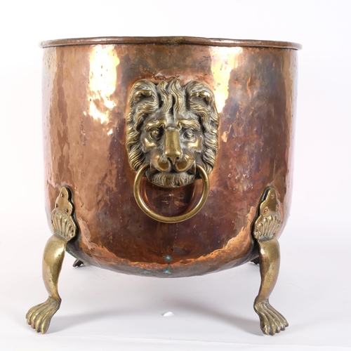 23 - A large Victorian hammered copper jardiniere, with cast-brass lion mask ring handles, and brass paw ... 