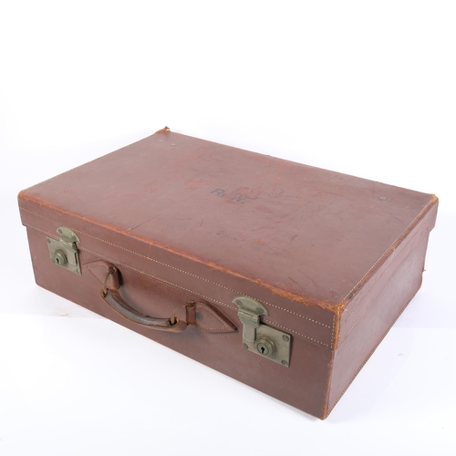 84 - An early 20th century leather-covered gentleman's travelling vanity suitcase, the lid opening to rev... 