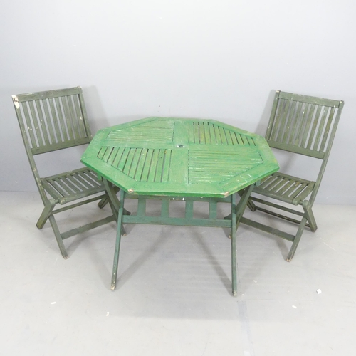 2617 - A painted teak octagonal folding garden table, 102x74cm, with two matching chairs.