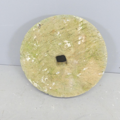 2622 - A weathered concrete millstone. Diameter 43cm.