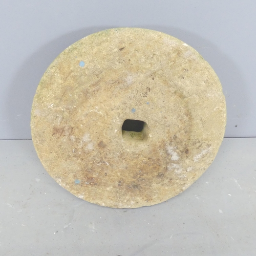 2622 - A weathered concrete millstone. Diameter 43cm.