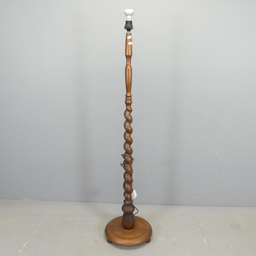 2651 - An oak standard lamp, with spiral turned column on platform base. Height to bayonet 143cm.