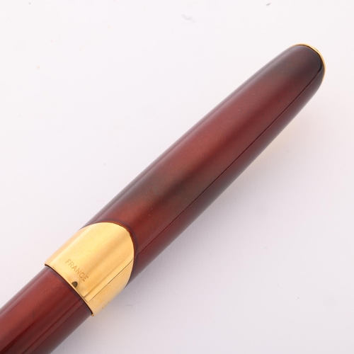 506 - A Parker Ellipse fountain pen, 18k gold nib, red lacquer body with gold plated mounts, in presentati... 