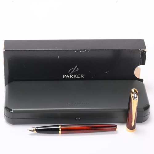 506 - A Parker Ellipse fountain pen, 18k gold nib, red lacquer body with gold plated mounts, in presentati... 