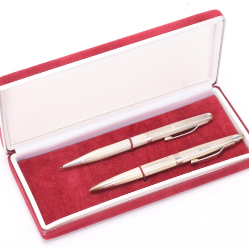 585 - A silver pen and pencil set, engine turned body, hallmarked Birmingham 1988, makers mark WM, boxed