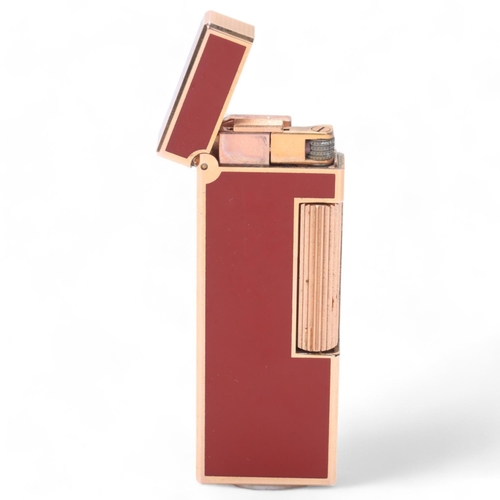 630 - A Dunhill slimline Rollagas lighter, gold plated with red lacquer body, makers marks to base, No1187... 