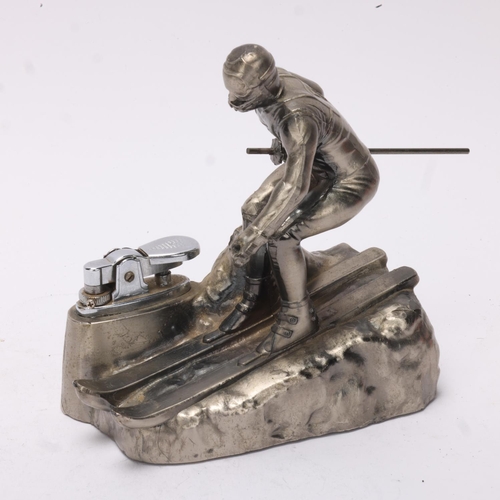 645 - A Comoys table lighter in the form of a downhill skier, aluminium base, height 12.5cm