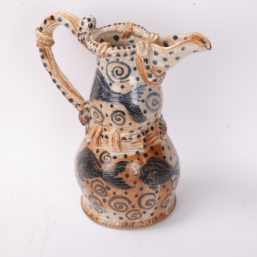 321 - A studio pottery stoneware jug with painted fish decoration, signed to base, height 25cm