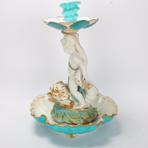 862 - A 19th century ceramic table centre, supported by a cherub riding a gurgle fish, no factory marks, h... 