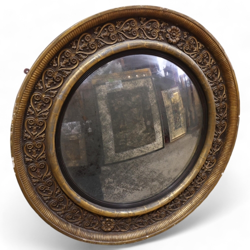 891 - A large Georgian convex mirror, with gilded relief carved wood and gesso surround, original oxidised... 