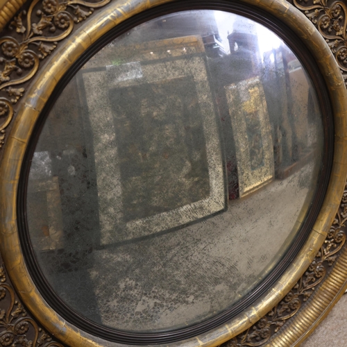 891 - A large Georgian convex mirror, with gilded relief carved wood and gesso surround, original oxidised... 