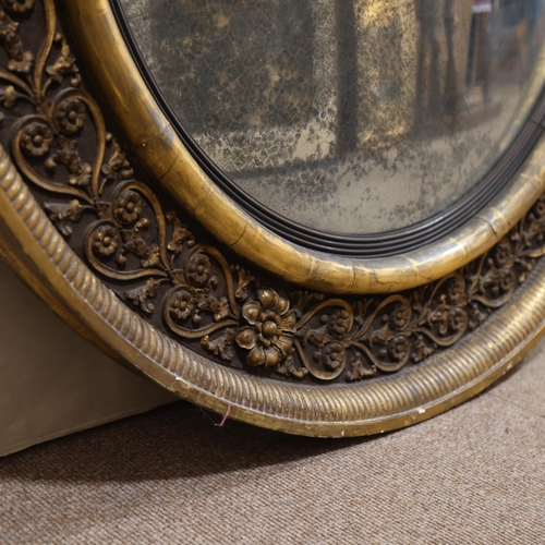 891 - A large Georgian convex mirror, with gilded relief carved wood and gesso surround, original oxidised... 