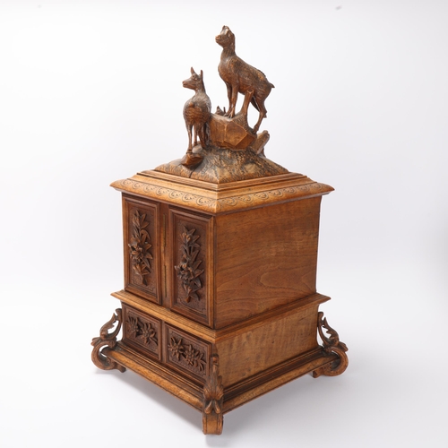 712 - An ornate 19th century Black Forest table cabinet, the lid surmounted a carved wood group of deer, 2... 