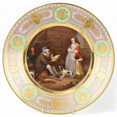 739 - A Vienna porcelain plate depicting a bird handler, gilded border, diameter 25.5cm