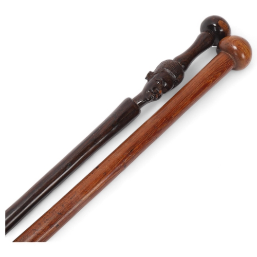 769 - A Zulu lignum vitae ball end stick, length 93cm, and an African hardwood stick with carved head (2)