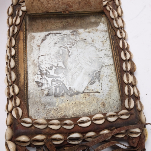 772 - An African Tribal chest plate, with inset mirror decorated with cowrie shells, approx 25cm x 19cm