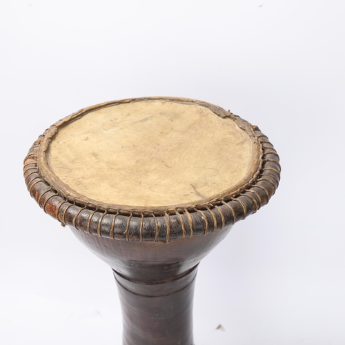 777 - A small African hollow stained wood drum with incised bands, height 40cm